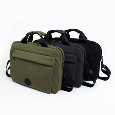 three laptop bags sitting next to each other on a white surface, one black and one green