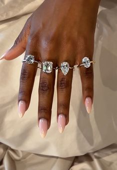 a woman's hand with three different rings on her fingers and two diamonds on the ring