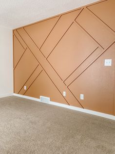 an empty room with a brown wall and tan carpet