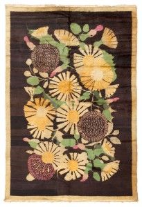 an old rug with yellow and brown flowers on black ground, in front of a white background