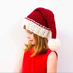 a woman wearing a knitted hat with pom - poms