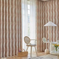 the living room is decorated in pink and white colors with curtains that are drawn back