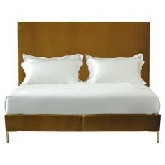 a bed with two white pillows on top of it next to a brown headboard