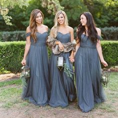 three beautiful women in long dresses standing next to each other