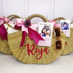 a straw basket with pink ribbon and personalized items on it, sitting on a table