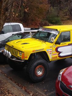 a yellow truck parked in a parking lot next to other cars