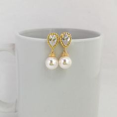 Simply Classic!!  I've created these charmings classic cubic zirconia and pearl bridal earrings in gold plated brass setting. Earrings feature teardrop clear cubic zirconia ear post and 10mm Swarovski pearl dangle drop. Total length of the earrings is 2.7 cms.For matching necklace click:https://www.etsy.com/listing/275221942/gold-pearl-and-crystal-bridal-necklace?ref=shop_home_active_15To browse my collection click :https://www.etsy.com/ shops/fantasycrystals Wedding Earrings Gold, Bridal Earrings Gold, Gold Wedding Earrings, Gold Earrings Wedding, Blue Crystal Earrings, Gold Bridal Earrings, Rose Gold Crystal, Bridal Earrings Pearl, Halo Earrings