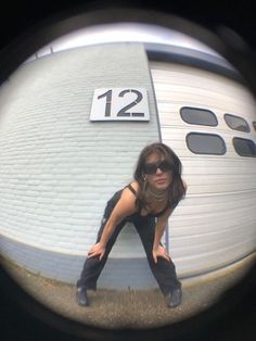 a woman in black shirt and sunglasses sitting on top of a surfboard with number 12 on it