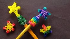 two pencils are laying next to some crocheted objects on a table top