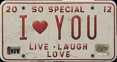 an old license plate with the words i love you written in red and white on it