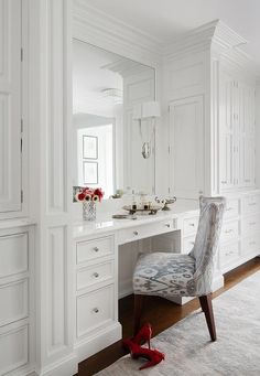 a white desk with a chair and mirror in the corner, along with other furniture