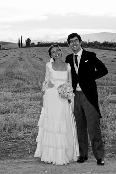 a man and woman standing next to each other in a field