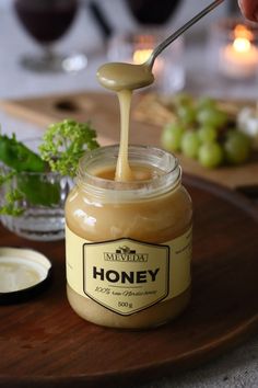 a jar of honey sitting on top of a wooden tray