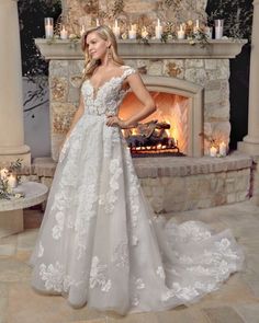 a woman standing in front of a fireplace wearing a wedding dress