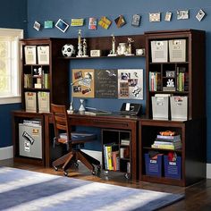 a room with blue walls and wooden shelves filled with books, papers and other items