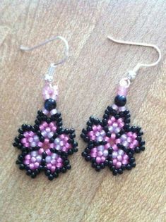 two pairs of beaded earrings sitting on top of a table