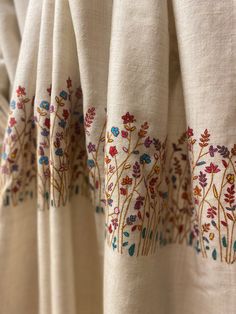 an embroidered curtain with flowers on it