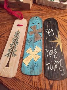 three wooden christmas door hangers on a table