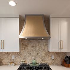 a stove top oven sitting inside of a kitchen next to white cabinets and cupboards