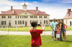 a group of people standing in front of a large house