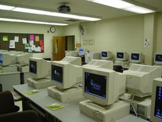 rows of computer monitors sitting on top of desks