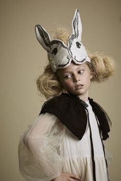 a woman wearing a mask with two rabbits on it's head and hair in pigtails