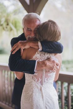 an older man and woman hugging each other