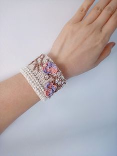 a woman's arm with a bracelet made out of crochet and beads