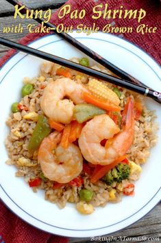 shrimp, corn and vegetable stir fry on rice with chopsticks in a white bowl