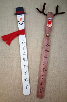 two wooden rulers decorated like snowmen with red noses and antlers on them