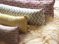 four decorative pillows sitting on top of a fur covered floor