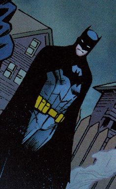 the batman is standing in front of some buildings