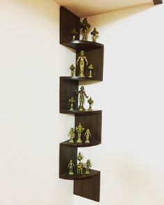 a corner shelf filled with small figurines on top of each other in front of a white wall