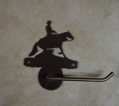 a horse and rider hook on the side of a toilet paper dispenser