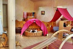 a room that has some kind of pink tent in the middle of it with other items on the floor