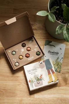 an open box with six different types of confections in it next to a plant