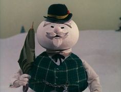 a snowman wearing a green jacket and hat