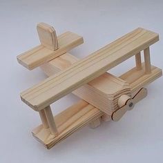 a wooden toy airplane with wheels on the front and back ends, made out of wood