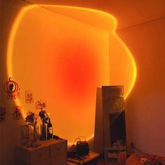 a room that has a mirror and some lights on the wall in it, with an orange light coming from the ceiling