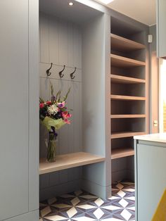 a vase filled with flowers sitting on top of a wooden shelf next to a wall