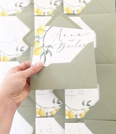 a person holding up a piece of paper with lemons on it in front of a wall