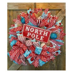 a wreath with the words north pole on it and red, white and blue decorations