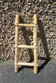 a wooden ladder leaning against a stone wall