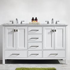 a white bathroom vanity with two sinks and marble counter tops on each side, against a white background