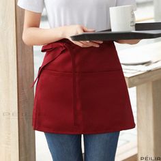 a woman holding a tray with a coffee cup on it and wearing a red skirt