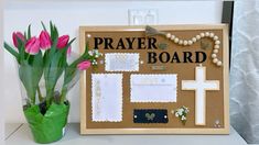 a bulletin board with flowers in a vase and a cross on the wall next to it