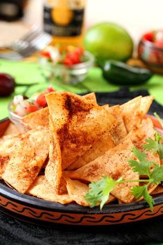 tortilla chips with cilantro and tomatoes on the side are ready to be eaten