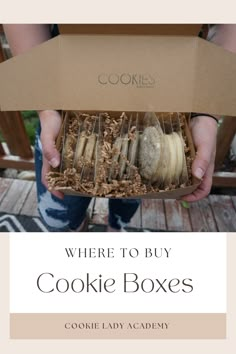 a person holding a box with cookies in it and the words where to buy cookie boxes