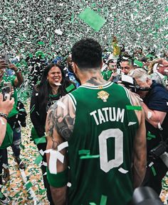 a man in a green jersey surrounded by confetti