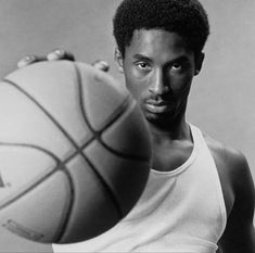 a man holding a basketball in his right hand and looking at the camera with an intense look on his face